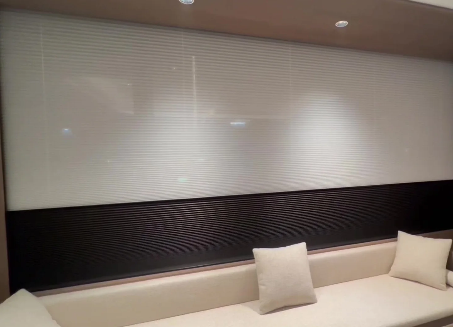 Day and night cellular honeycomb shade in a warm interior, sheer band above and blackout band below
