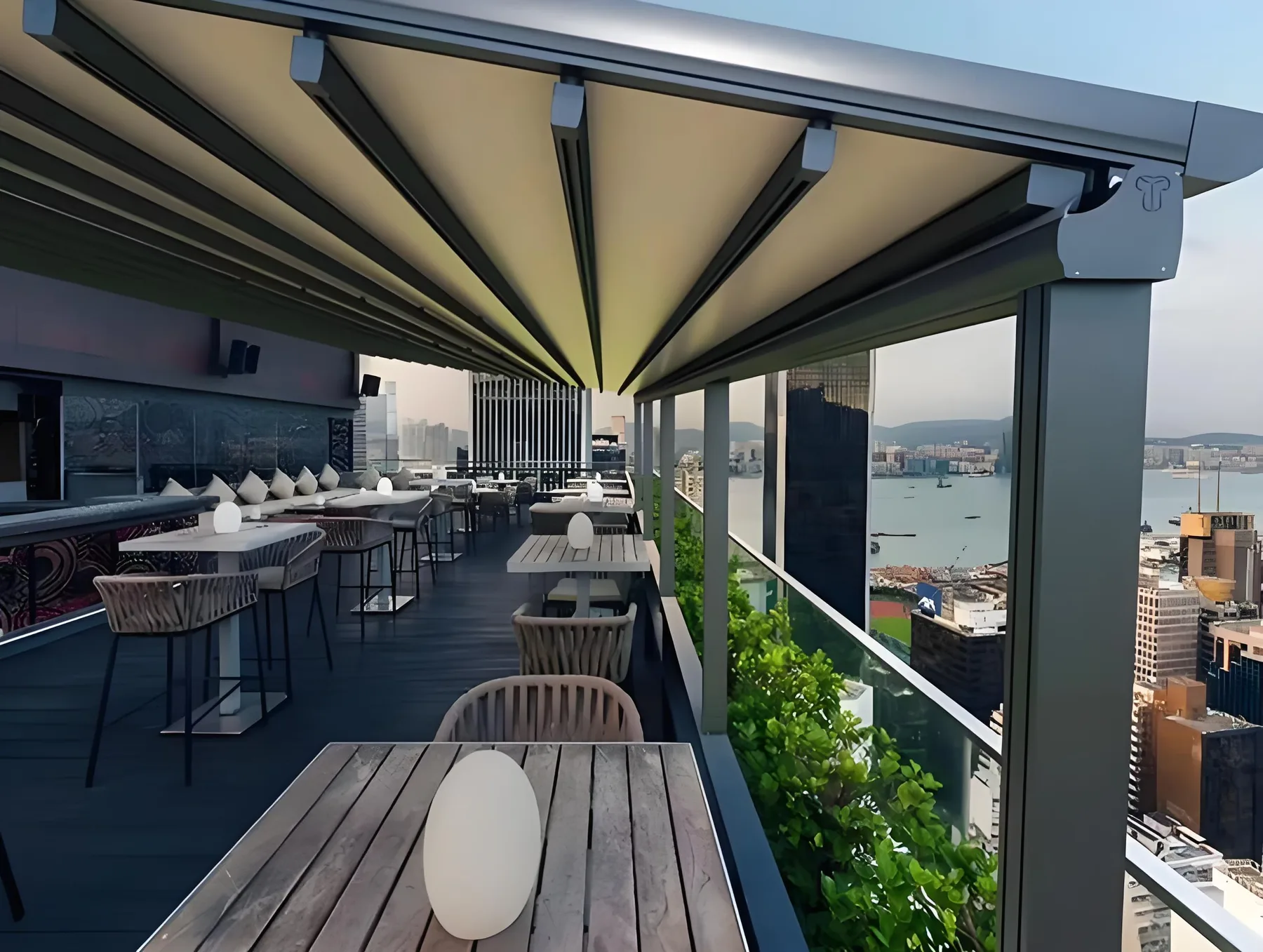Retractable folding awning over a rooftop terrace with a sea view